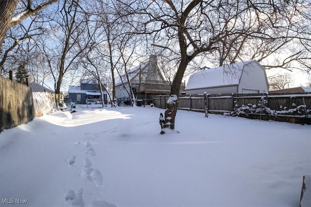 yard covered in snow featuring a garage and fence