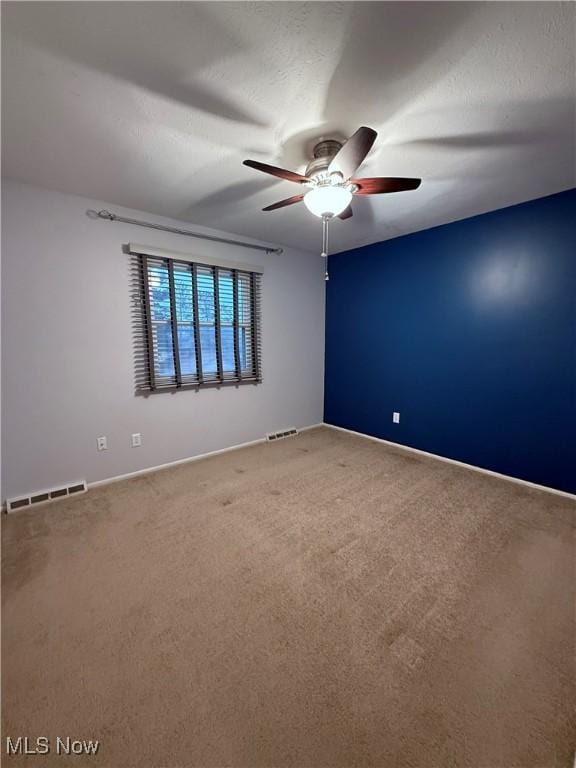 unfurnished room featuring carpet floors, ceiling fan, and visible vents