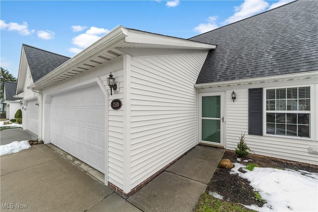 exterior space with roof with shingles, concrete driveway, and an attached garage