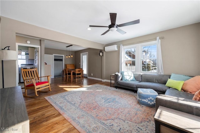 living room with recessed lighting, wood finished floors, a ceiling fan, baseboards, and a wall mounted AC