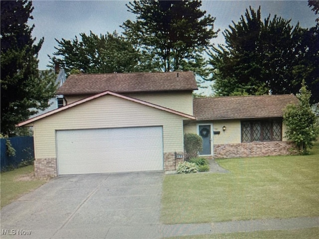 view of front of home featuring brick siding, an attached garage, a front yard, fence, and driveway