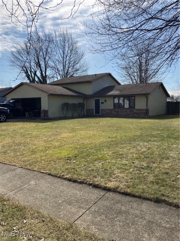 view of front of property with an attached garage and a front lawn