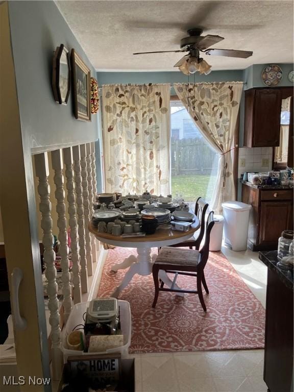 dining room with a textured ceiling and ceiling fan