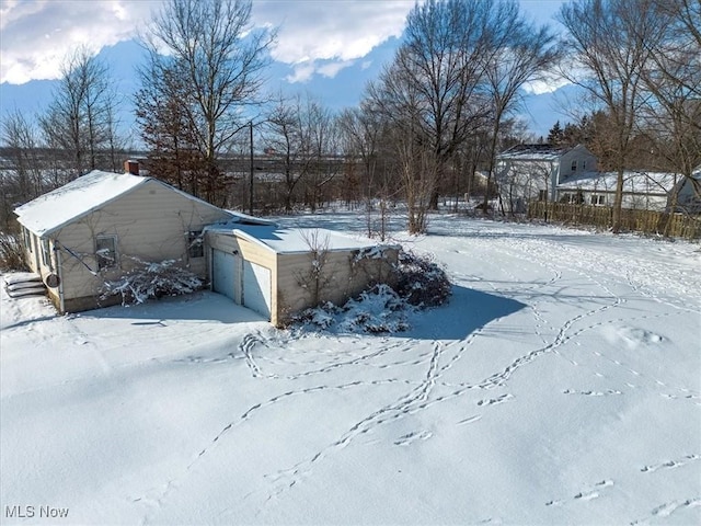 yard layered in snow with a detached garage