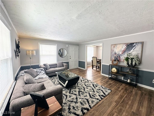 living room featuring a textured ceiling, ornamental molding, dark wood finished floors, and baseboards