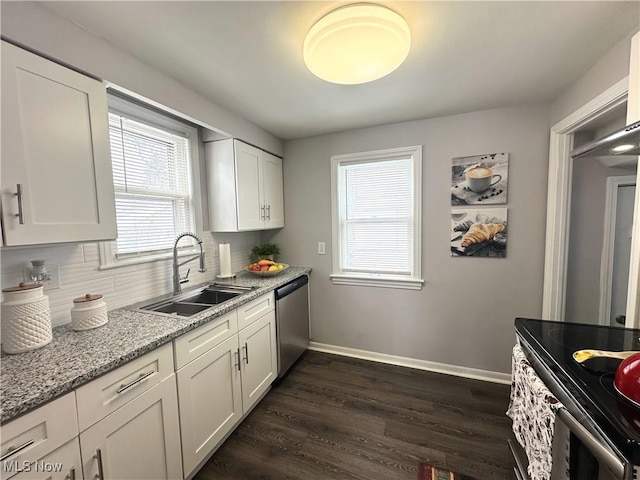 kitchen featuring stainless steel appliances, dark wood-type flooring, a sink, baseboards, and decorative backsplash