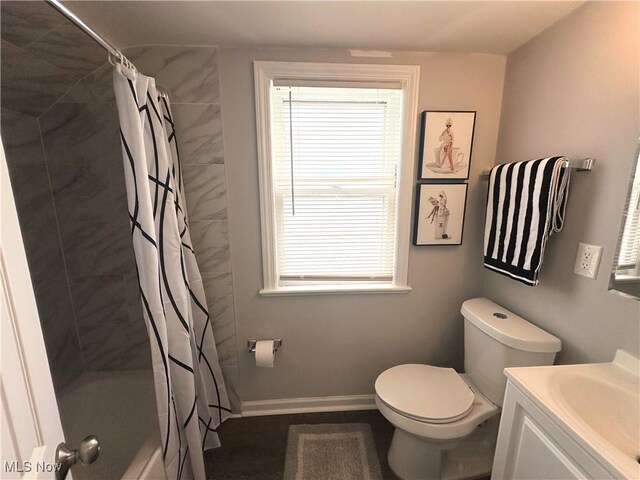 full bath with toilet, baseboards, shower / tub combo with curtain, and vanity