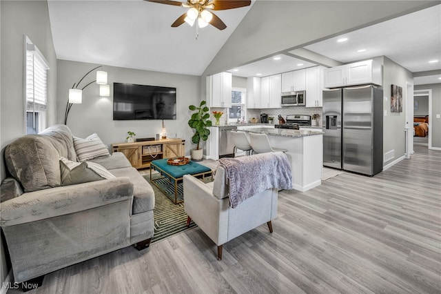 living area featuring light wood-style flooring, visible vents, baseboards, and recessed lighting