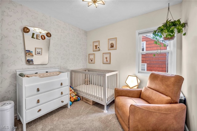 carpeted bedroom with a crib and wallpapered walls