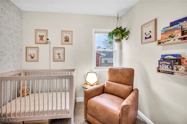 bedroom with a crib, wallpapered walls, baseboards, and carpet floors