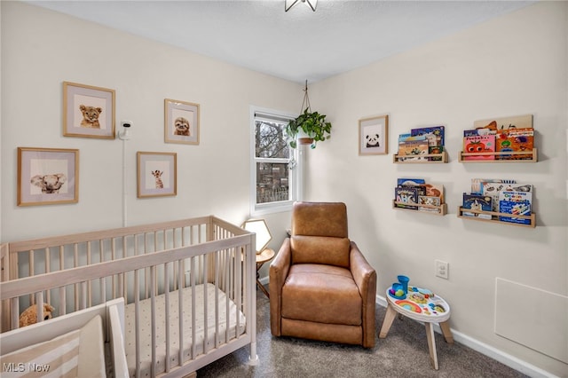 carpeted bedroom with a crib and baseboards