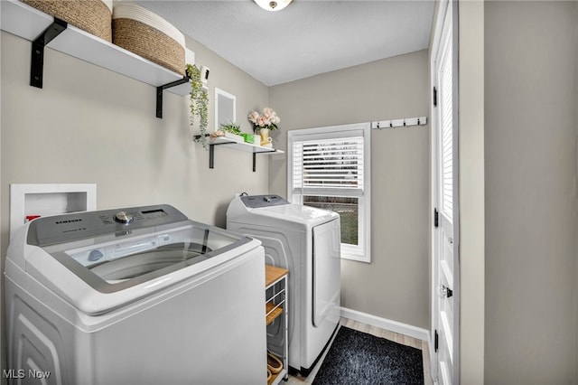 laundry area featuring laundry area, separate washer and dryer, wood finished floors, and baseboards