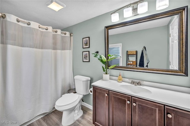 full bathroom featuring toilet, curtained shower, wood finished floors, and vanity