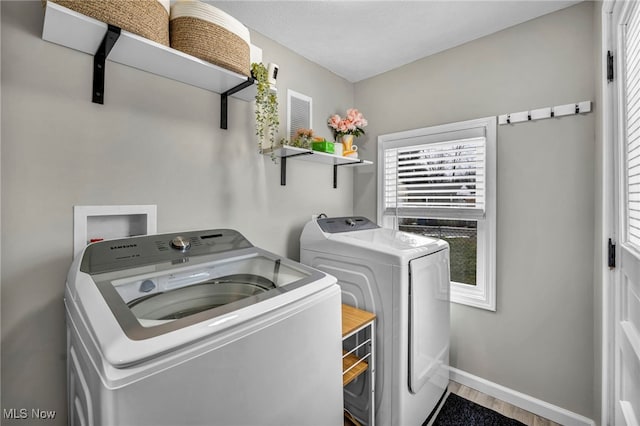 laundry room with laundry area, washer and clothes dryer, wood finished floors, and baseboards