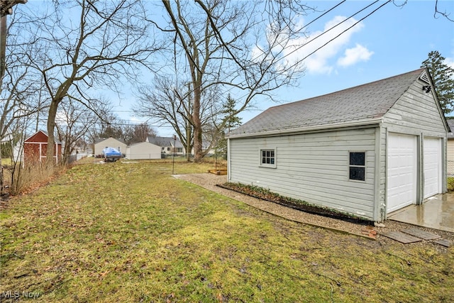 view of yard featuring an outdoor structure, fence, and a detached garage