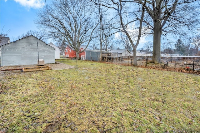 view of yard with fence and an outdoor structure