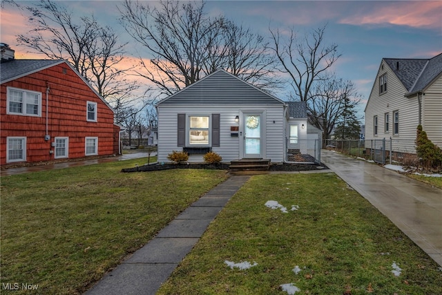 bungalow-style house with fence and a yard