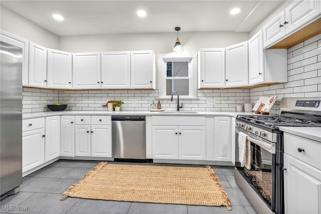 kitchen with light countertops, appliances with stainless steel finishes, a sink, and white cabinetry