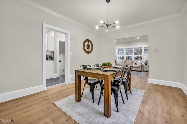 dining area with light wood-style floors, crown molding, and baseboards