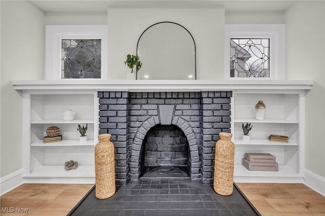 details with a fireplace, wood finished floors, built in features, and baseboards