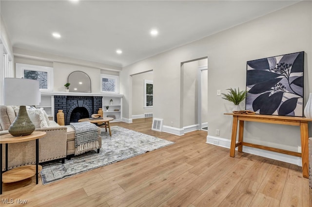 living room with recessed lighting, a fireplace, wood finished floors, visible vents, and baseboards