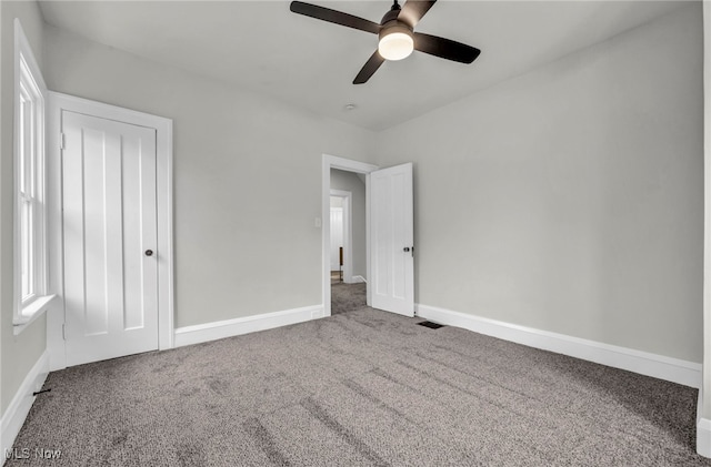 unfurnished bedroom with carpet, ceiling fan, and baseboards