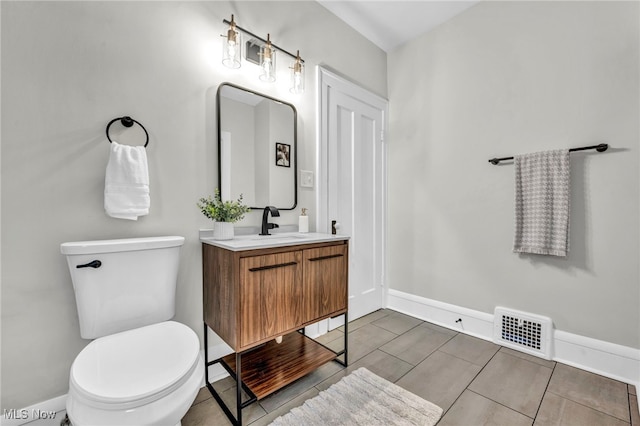 bathroom with baseboards, visible vents, vanity, and toilet