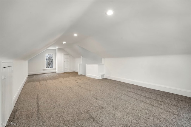 additional living space featuring baseboards, visible vents, vaulted ceiling, carpet flooring, and recessed lighting