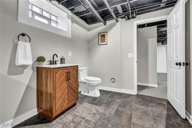 bathroom with vanity, toilet, and baseboards