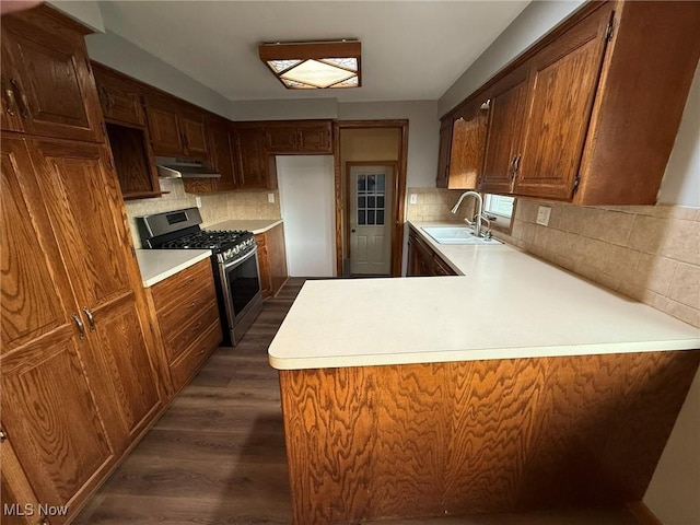 kitchen featuring light countertops, stainless steel gas stove, and a sink