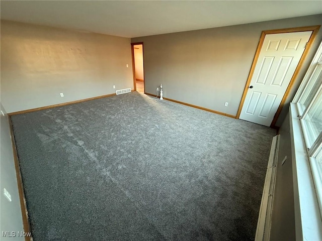 unfurnished room featuring carpet, baseboards, and visible vents