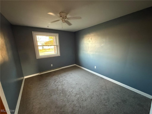 empty room featuring a baseboard heating unit, baseboards, dark carpet, and a ceiling fan