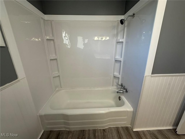 full bath with a wainscoted wall, bathtub / shower combination, and wood finished floors