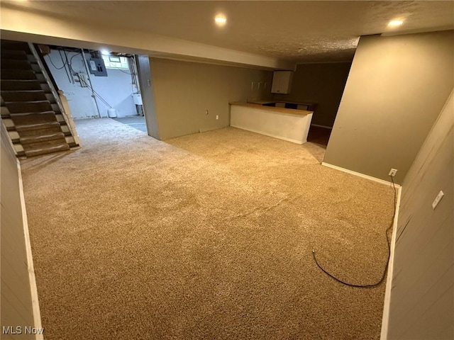 finished basement with electric panel, stairway, carpet flooring, and recessed lighting