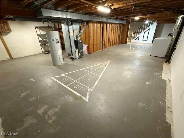 unfinished below grade area featuring heating unit, washer / dryer, and water heater