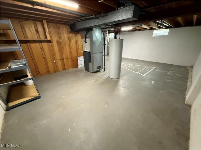 basement featuring water heater and heating unit