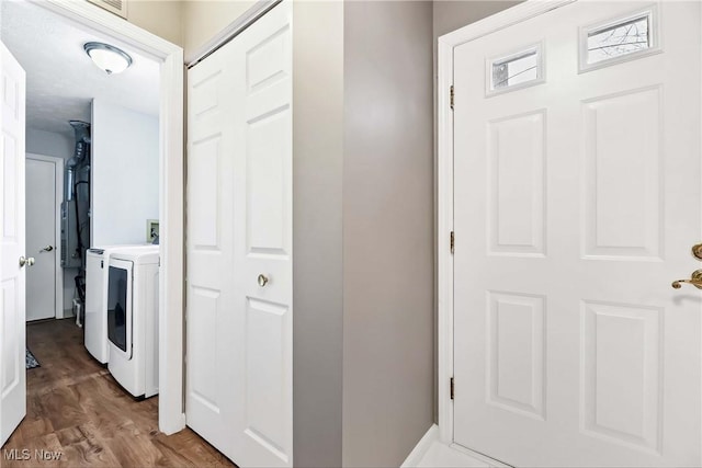 corridor featuring independent washer and dryer and wood finished floors