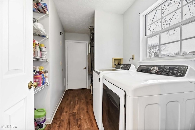 clothes washing area featuring a textured ceiling, laundry area, separate washer and dryer, dark wood-style flooring, and baseboards