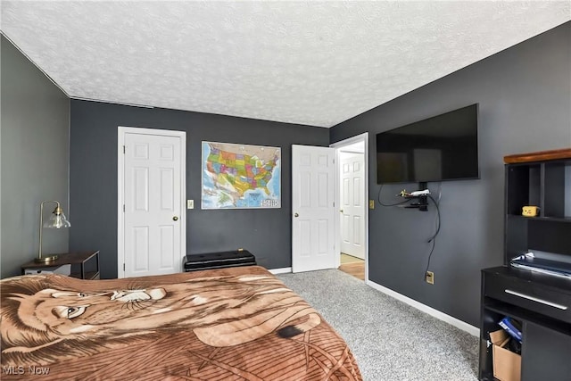 carpeted bedroom featuring a textured ceiling and baseboards