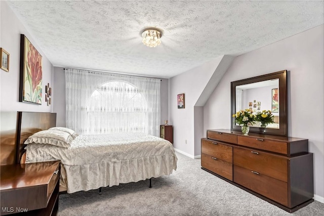 bedroom with a textured ceiling, carpet floors, and baseboards