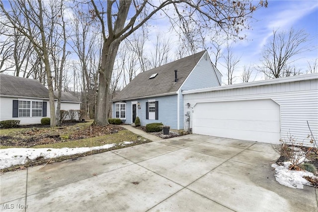 new england style home featuring a garage, driveway, and roof with shingles