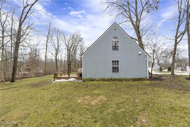 view of home's exterior with a yard and a wooden deck