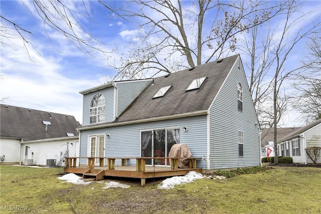 rear view of house with central AC, a deck, a lawn, and roof with shingles