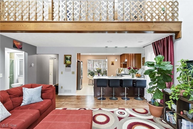 living area featuring visible vents and wood finished floors