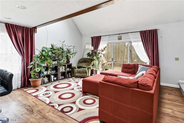 living area featuring vaulted ceiling, wood finished floors, and baseboards