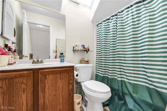 bathroom with curtained shower, vanity, and toilet