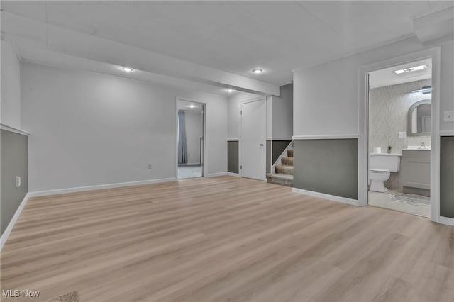 below grade area with stairs, baseboards, wood finished floors, and recessed lighting