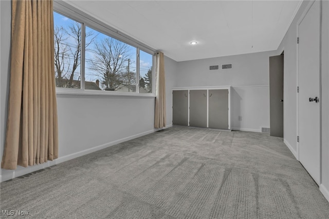 unfurnished bedroom with carpet flooring, visible vents, and baseboards