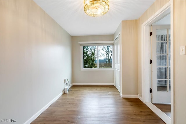 unfurnished room featuring wood finished floors and baseboards