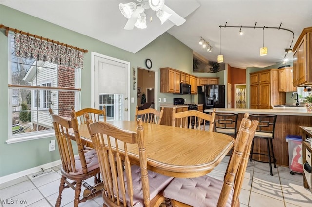 dining area featuring light tile patterned floors, baseboards, visible vents, a ceiling fan, and lofted ceiling